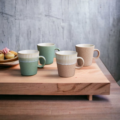 set of four fluted stoneware tea or  coffee mugs in light pink cream and light green tones 275ml sitting on a wooden board with tea cakes